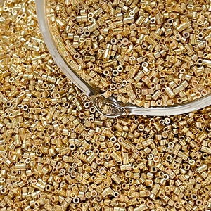 Macro shot of gold cylinder glass seed beads with metallic finish for DIY jewelry making