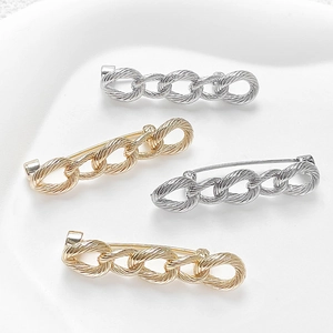 Detailed macro of vintage twisted chain link brooches in polished gold and silver finish