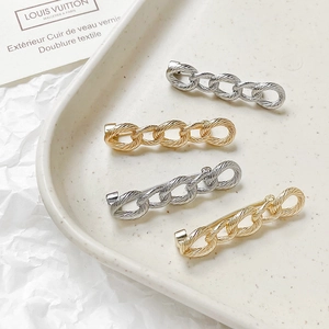 French style 18k gold and silver plated chain link brooches on a ceramic tray