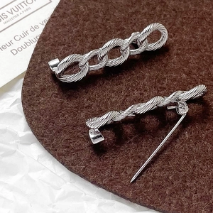 Macro shot of silver woven twist metal brooch pins for DIY jewelry making accessories