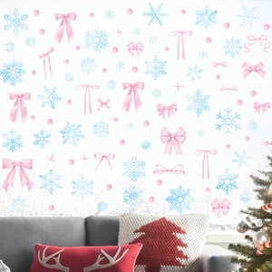 Adesivi con fiocco rosa e fiocchi di neve su finestra con decorazioni natalizie calde