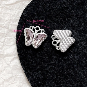 Makro-Detail von rosa Schmetterlingsanhängern mit Kristallinlay und Metallstruktur