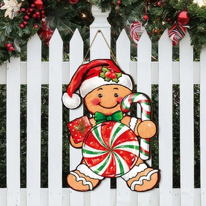 Détail d'un panneau en bois bonhomme de pain d'épices sur une clôture blanche de Noël