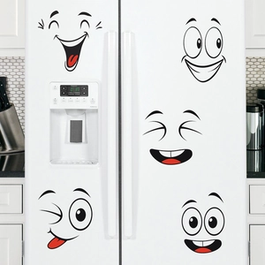 Funny cartoon face stickers set on a white refrigerator in a modern kitchen scene