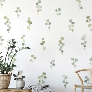 Close-up of watercolor eucalyptus leaf wall stickers in a cozy Nordic living room setup