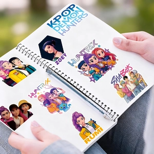 Detail of K-POP DEMON HUNTERS waterproof PVC stickers applied to a white spiral notebook