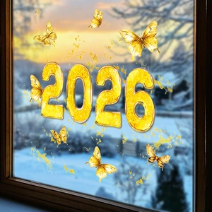 Detail von glitzernden goldenen 2026 Schmetterling-Fensteraufklebern vor Schneelandschaft