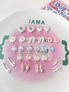 Dettaglio di ciondoli metallici fai-da-te colori macaron su un piatto di ceramica bianca