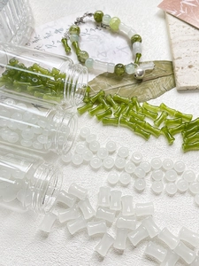 Dettaglio di perle in vetro a forma di bambù verdi e bianche per gioielli fai da te