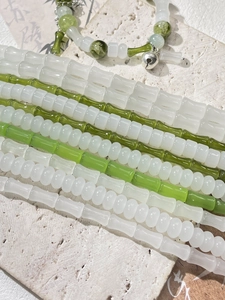 Vista macro di perle di vetro a forma di bambù in tonalità giada con ciondoli a campanello