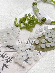 Dettaglio macro di perline in vetro a forma di bambù verde e componenti per gioielli DIY