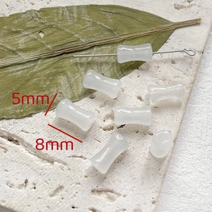 Dettaglio di perle di bambù in vetro bianco 8x5mm per gioielli fai da te su pietra