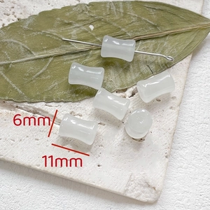 Dettaglio macro di perline di bambù bianco traslucido 6x11mm per gioielli fai da te