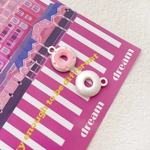 Dettaglio di ciondoli a forma di ciambella in resina con smalto rosa per gioielli fai da te