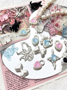 Detailed Y2K DIY jewelry charms featuring resin rabbits and iridescent hearts on a mirror