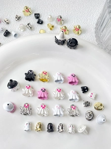 Close-up of assorted Halloween ghost beads in gold, silver and enamel for DIY jewelry