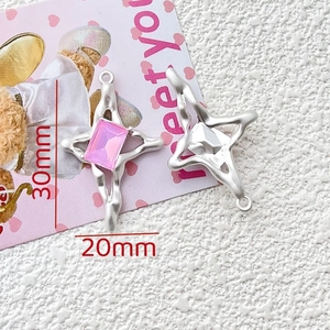 Detailed view of silver cross star charms with pink stone inlay and 30mm dimensions