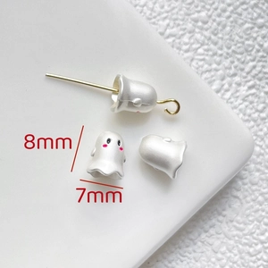 Macro shot of 8x7mm matte white ghost charm beads with pink cheeks for DIY jewelry making