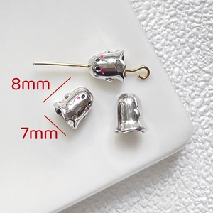 Macro shot of 8x7mm silver ghost charms with pink enamel eyes for DIY jewelry making