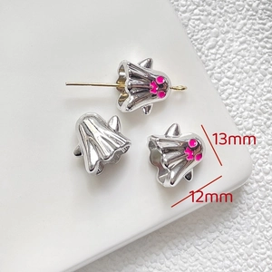 Macro shot of silver ghost charms with pink details for Halloween jewelry making