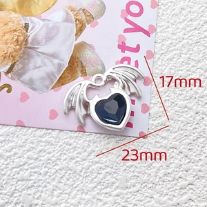 Detailed macro view of heart pendant with blue gemstone and bat wings, 23mm x 17mm