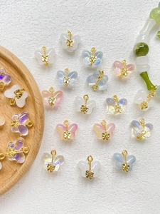 Detailed macro view of colorful glaze butterfly charms with gold alloy loops for DIY jewelry