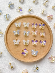 Macro view of colorful butterfly resin charms with golden bows for jewelry making