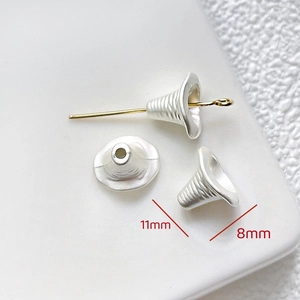 Macro detail of 11mm silver spiral textured bell beads for DIY jewelry making