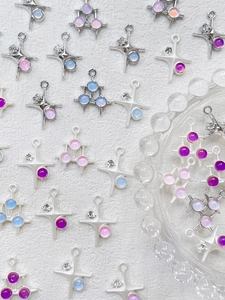 Makroaufnahme verschiedener Stern- und Dreieck-Anhänger für DIY-Schmuck mit Pastellsteinen