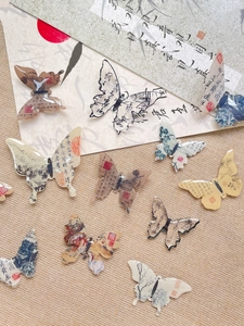 Detailed view of butterfly charms with traditional Chinese ink painting and calligraphy motifs