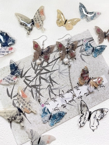 Detail of Chinese style butterfly earrings with calligraphy, ink painting and long tassels