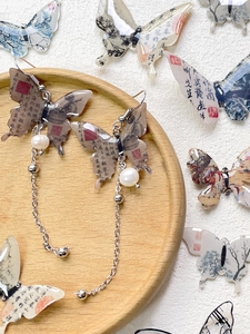 Detail of Chinese calligraphy butterfly earrings with white pearl and silver tassels