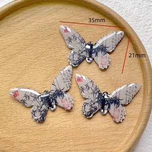 Macro detail of ink-wash butterfly charms for DIY jewelry making, 35mm x 21mm size