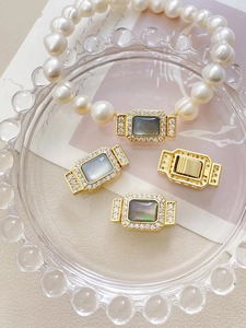 Gros plan sur les fermoirs en nacre dorée pour bracelets de perles artisanaux