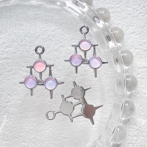 Detailansicht von drei silbernen geometrischen Anhängern mit lila Steinen für DIY-Schmuck