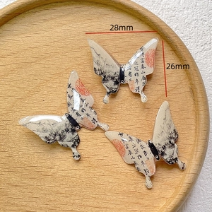 Detail of calligraphy butterfly charms with dimensions in millimeters for DIY crafts