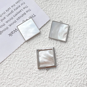 Vista macro de colgantes cuadrados de plata con incrustación de nácar blanco para joyas