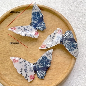 Macro shot of 48x30mm butterfly charm with ink painting and calligraphy design