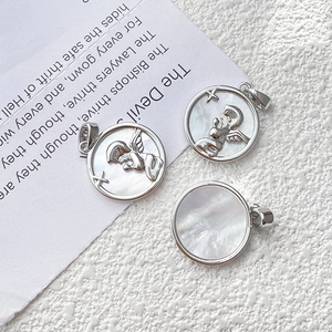 Detalle de colgantes de ángel en plata con nácar iridiscente y acabado pulido brillante