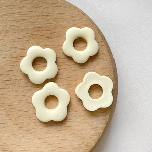 Vue macro de breloques fleurs en résine crème pour épingles à cheveux et DIY