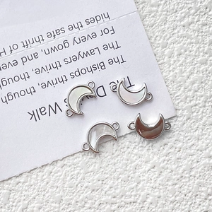 Detalle macro de conectores de nácar en forma de luna para creación de joyas