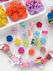 Macro van kleurrijke acryl golfkralen en M-bedeltjes voor DIY-sieraden maken