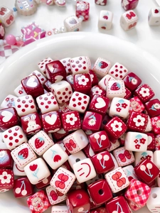 Gros plan de perles carrées en acrylique rouges et blanches aux motifs mignons
