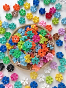 Macro-opname van kleurrijke acryl golfkralen en bloem-spacers voor DIY-sieraden