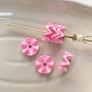 Macrodetail van roze golfvormige acrylkralen voor DIY-sieraden en handgemaakte armbanden