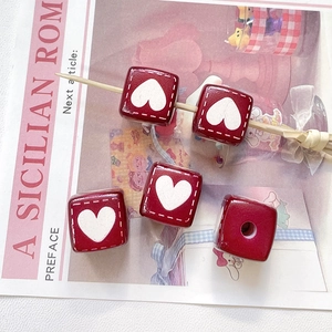 Gros plan de perles cubes rouge foncé avec motif cœur pour bijoux DIY et colliers