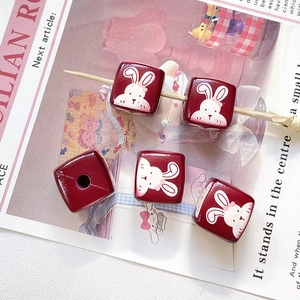 Détail de perles carrées en bois rouge avec lapin blanc mignon pour la création de bijoux DIY