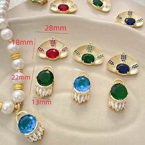 Detailed view of gold-plated evil eye charms with colorful zircon stones and tassels