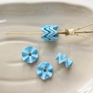 Macro-opname van lichtblauwe golvende acrylkralen voor DIY sieraden en armbanden
