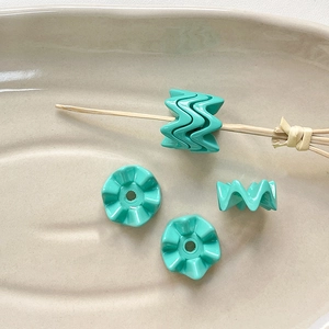Detailopname van gegolfde tiffany blauwe acryl kralen op een tak voor DIY-sieraden